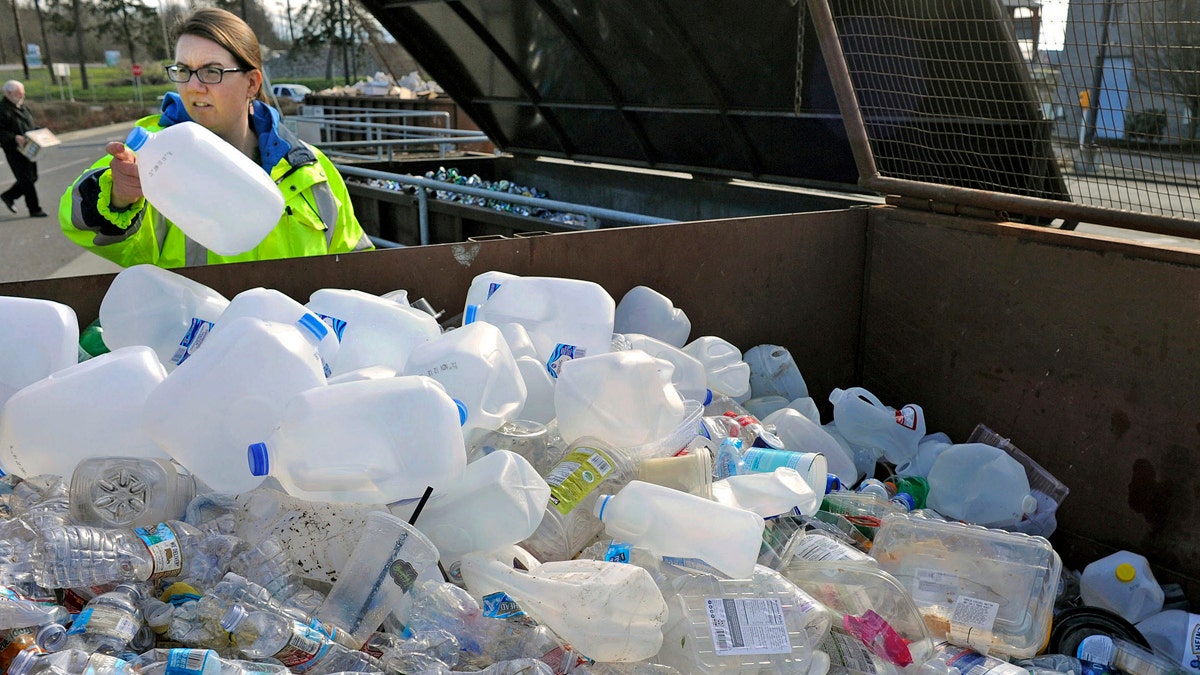 FILE - In this March 12, 2018, file photo, Skagit County Solid Waste Division manager Margo Gillaspy displays some of the recyclable plastic items that had been deposited at the Skagit County Transfer Station at Ovenell Road in Mt. Vernon, Wash. A scientific study published Wednesday, June 20, 2018, said China's 2017 decision to stop accepting plastic waste from other countries is causing plastic to stockpile around the globe. (Scott Terrell/Skagit Valley Herald via AP, File)