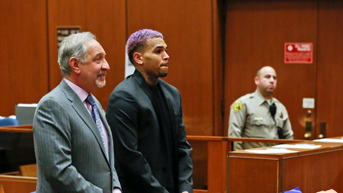 Chris Brown, right, appears with his attorney Mark Geragos, at a court hearing in the R&B singer's long-running case over his 2009 attack on Rihanna in Los Angeles on Friday, March 20, 2015. The judge closed Brown's assault case by revoking Brown's probation. (AP Photo/Mario Anzuoni, Pool)