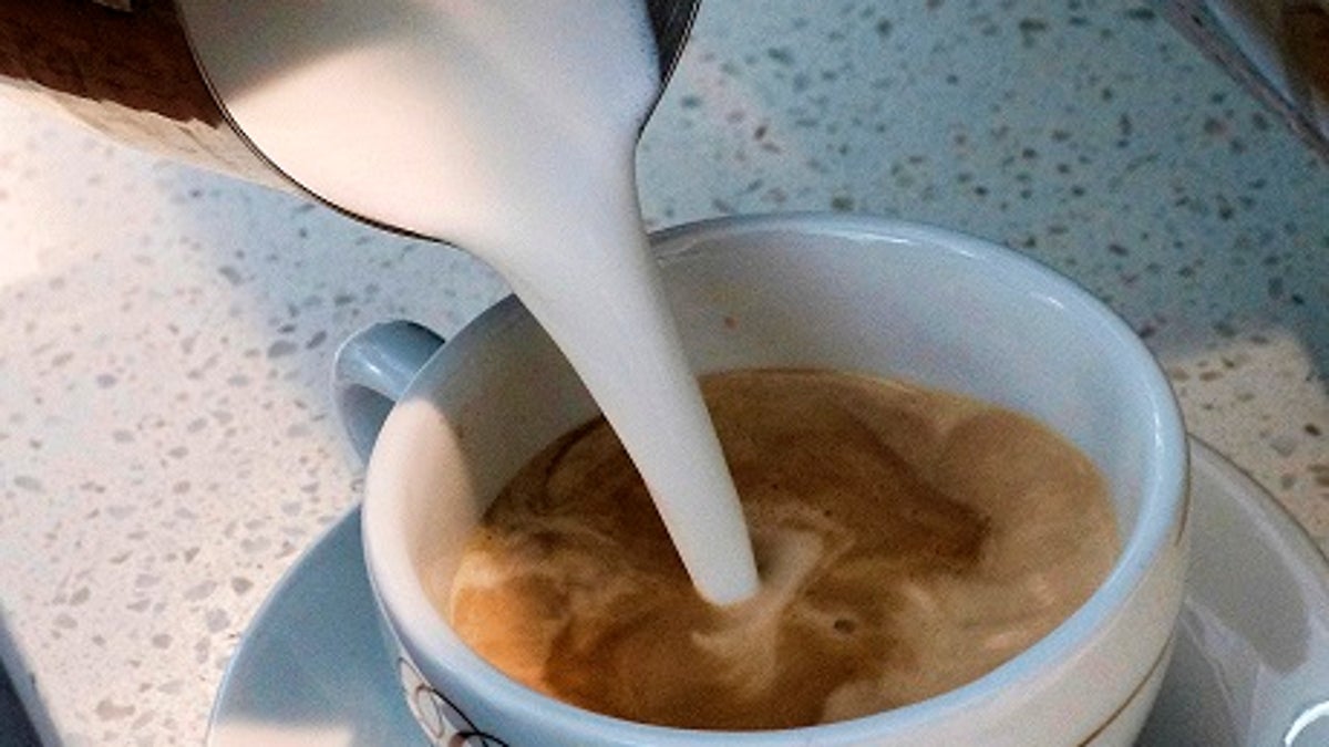 In this photo taken Friday, Sept. 22, 2017, a barista pours steamed milk in a coffee at a cafe in Los Angeles. In a long-running court case playing out in a Los Angeles courtroom, a nonprofit has been presenting evidence to show that coffee companies should post ominous warning labels about a cancer-causing chemical in every cup. (AP Photo/Richard Vogel)