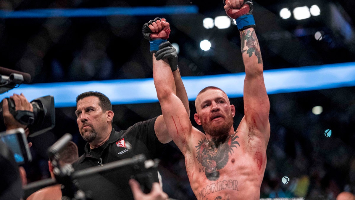 Aug 20, 2016; Las Vegas, NV, USA; Conor McGregor (blue gloves) reacts to fight with Nate Diaz (red gloves) during UFC 202 at T-Mobile Arena.