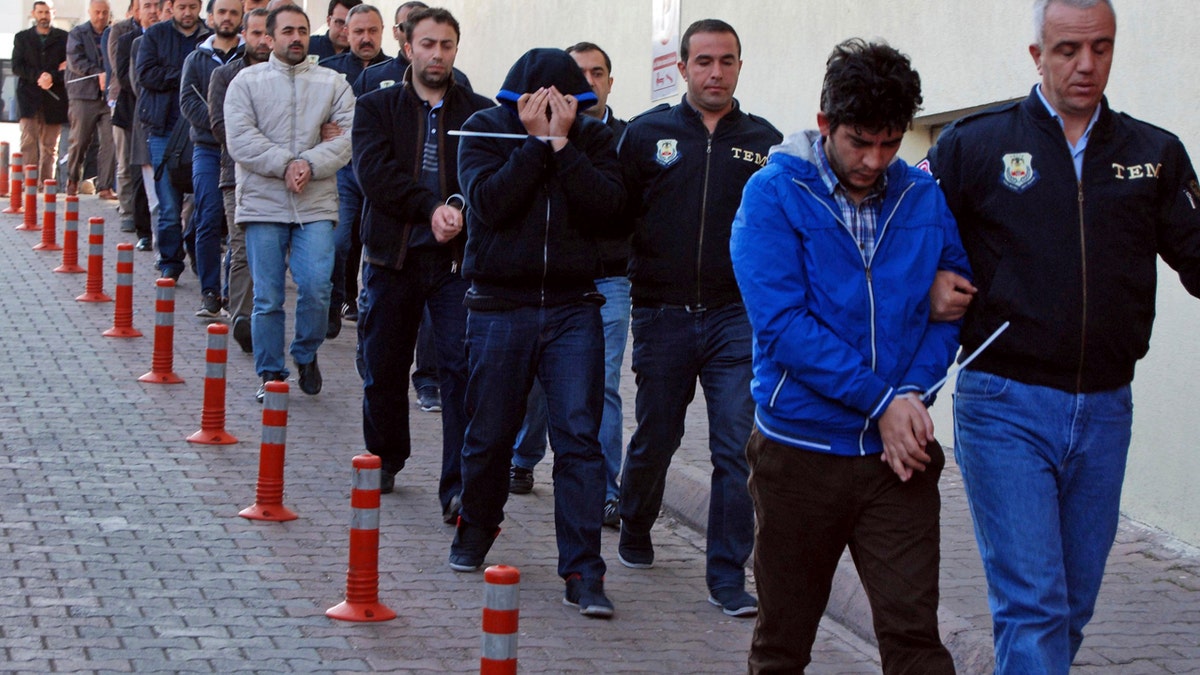 Police officers escort people, arrested because of suspected links to U.S.-based cleric Fethullah Gulen, in Kayseri, Turkey, Wednesday, April 26, 2017. Police launched simultaneous operations across the country on Wednesday, detaining hundreds of people with suspected links to U.S.-based cleric Fethullah Gulen. The suspects are allegedly Gulen operatives who directed followers within the police force. (Olay Duzgun/DHA-Depo Photos via AP)