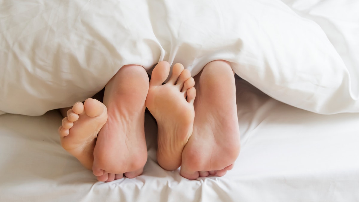 couple feet in bed sex istock