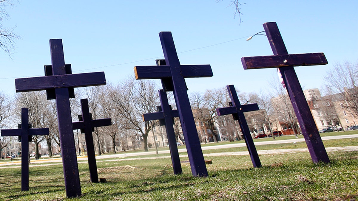 FILE - In this Thursday, April 19, 2018 file photo, crosses representing victims of gun violence stand outside Collins Academy High School in Chicago's North Lawndale neighborhood. With frustration mounting over lawmakers' inaction on gun control, the American Medical Association on Tuesday, June 12, 2018, pressed for a ban on assault weapons and came out against arming teachers as way to fight what it calls a public health crisis. (AP Photo/Martha Irvine)