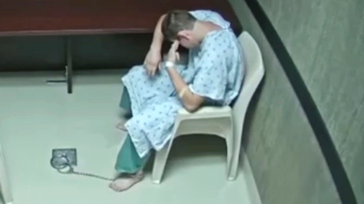 In this image made from video provided on Wednesday, Aug. 8, 2018, by the Broward County Sheriff's Office, Nikolas Cruz points his fingers to his temple at an interrogation room, while officers are out of the room, in Fort Lauderdale, Fla. Prosecutors on Wednesday released hours of video interrogation of Florida's school shooting suspect, footage showing the young man slouching in a chair, being repeatedly urged by a detective to speak louder and punching himself in the face when he is alone. (Broward County Sheriff's Office via AP)