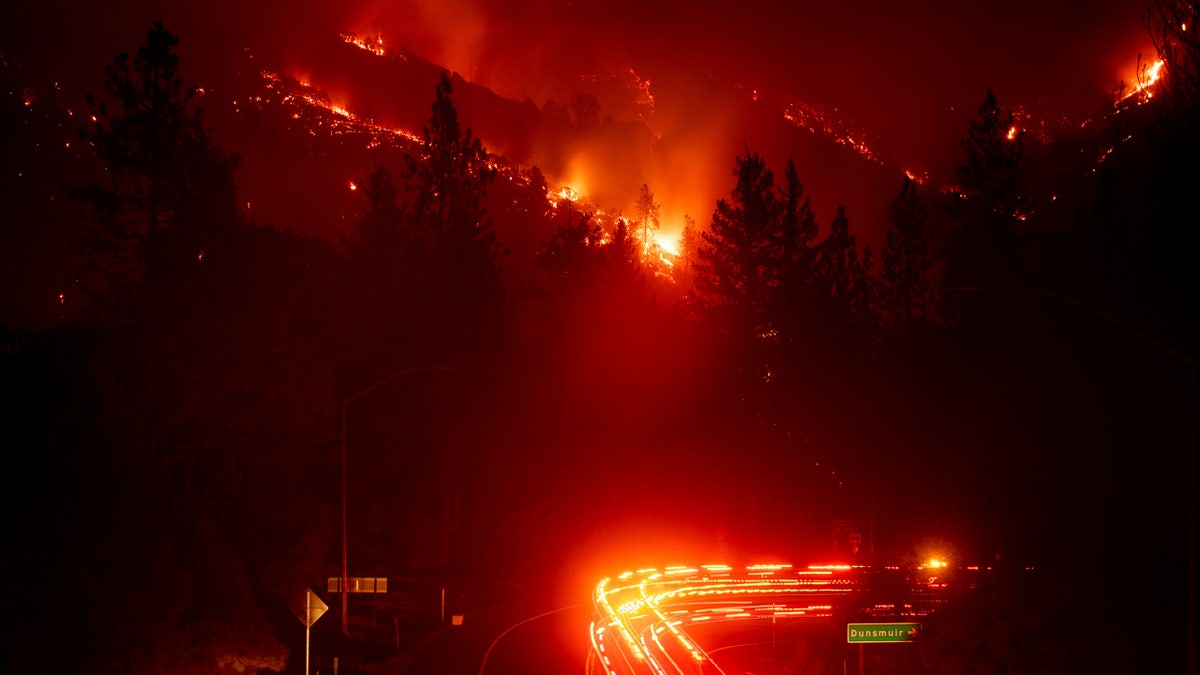 Fire trucks pass the Delta Fire burning in the Shasta-Trinity National Forest, Calif., on Wednesday, Sept. 5, 2018. Parked trucks lined more than two miles of Interstate 5 as both directions remained closed to traffic. (AP Photo/Noah Berger)
