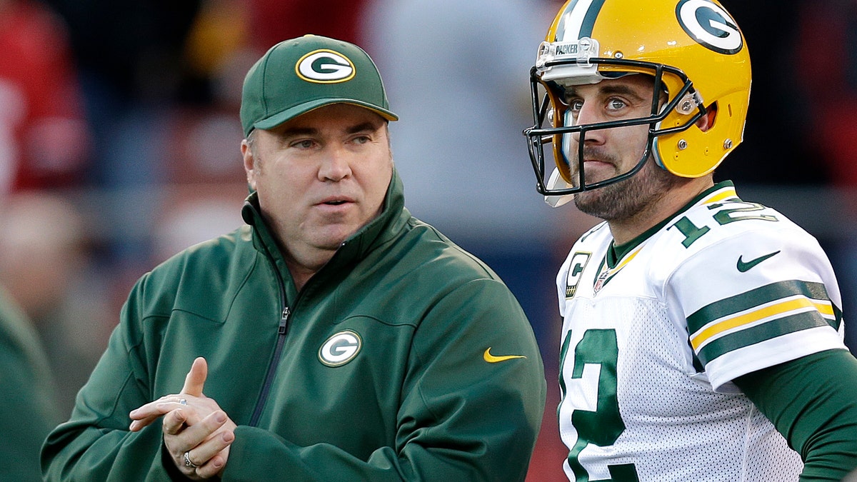 Mike McCarthy talks with quarterback Aaron rodgers
