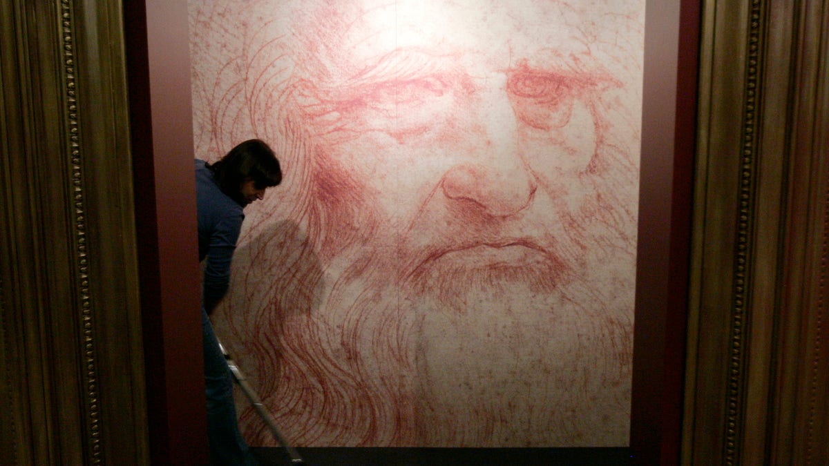 A cleaner vacuums in front of a Leonardo da Vinci self-portrait drawn around 1515 or 1516, during the inauguration of the exhibition 