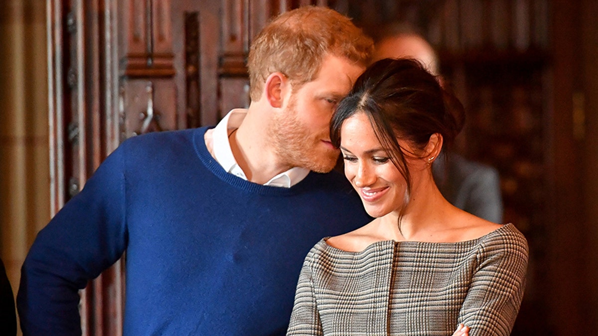 Britain's Prince Harry whispers to Meghan Markle as they watch a performance by a Welsh choir in the banqueting hall during a visit to Cardiff Castle in Cardiff, Britain, January 18, 2018. REUTERS/Ben Birchall/Pool - RC1A838B7CC0