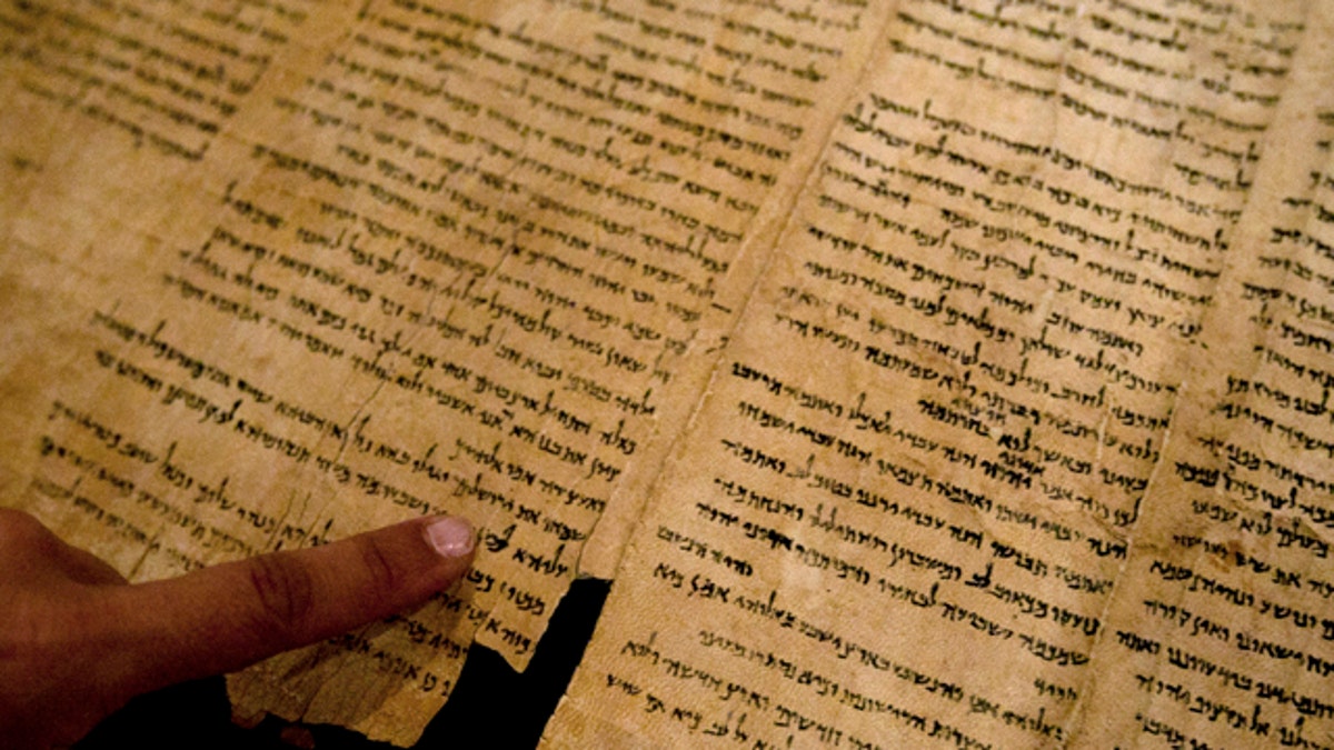 Sept. 26, 2011: An Israel Museum worker points at the word 