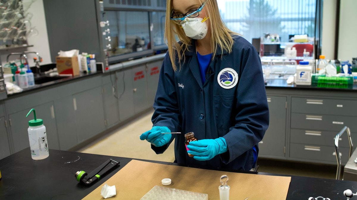 In this Tuesday, Aug. 9, 2016 photo, Drug Enforcement Administration (DEA) Forensic Chemist Emily Dye, prepares a control reference sample of fentanyl at the DEA's Special Testing and Research Laboratory in Sterling, Va. A novel class of deadly drugs is exploding across the country, with many manufactured in China for export around the world. The drugs, synthetic opioids, are fueling the deadliest addiction crisis the U.S. has ever seen. (AP Photo/Cliff Owen)