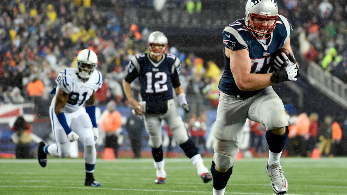 Jan 18, 2015; Foxborough, MA, USA; New England Patriots tackle Nate Solder (77) catches a pass from quarterback Tom Brady (12) and runs for a touchdown against the Indianapolis Colts in the third quarter in the AFC Championship Game at Gillette Stadium. Mandatory Credit: Robert Deutsch-USA TODAY Sports - RTR4LXBN
