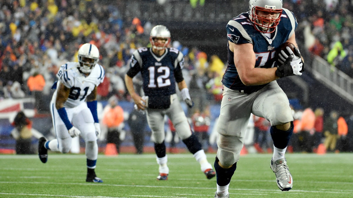 Jan 18, 2015; Foxborough, MA, USA; New England Patriots tackle Nate Solder (77) catches a pass from quarterback Tom Brady (12) and runs for a touchdown against the Indianapolis Colts in the third quarter in the AFC Championship Game at Gillette Stadium. Mandatory Credit: Robert Deutsch-USA TODAY Sports - RTR4LXBN