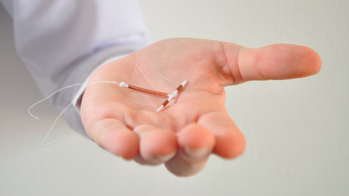 doctor holding an IUD istock large