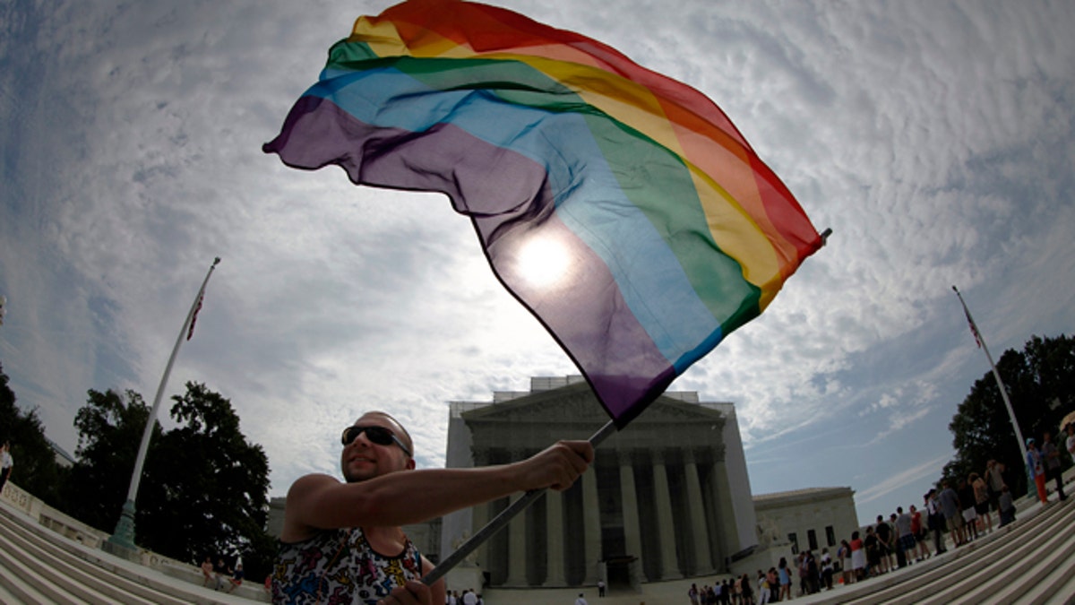 June 24, 2013: Gay marriage supporter Vin Testa waves a rainbow flag in anticipation of U.S. Supreme Court rulings in the cases against California&#39;s gay marriage ban known as Prop 8 and the 1996 federal Defense of Marriage Act (DOMA), outside the court building in Washington. (Reuters)