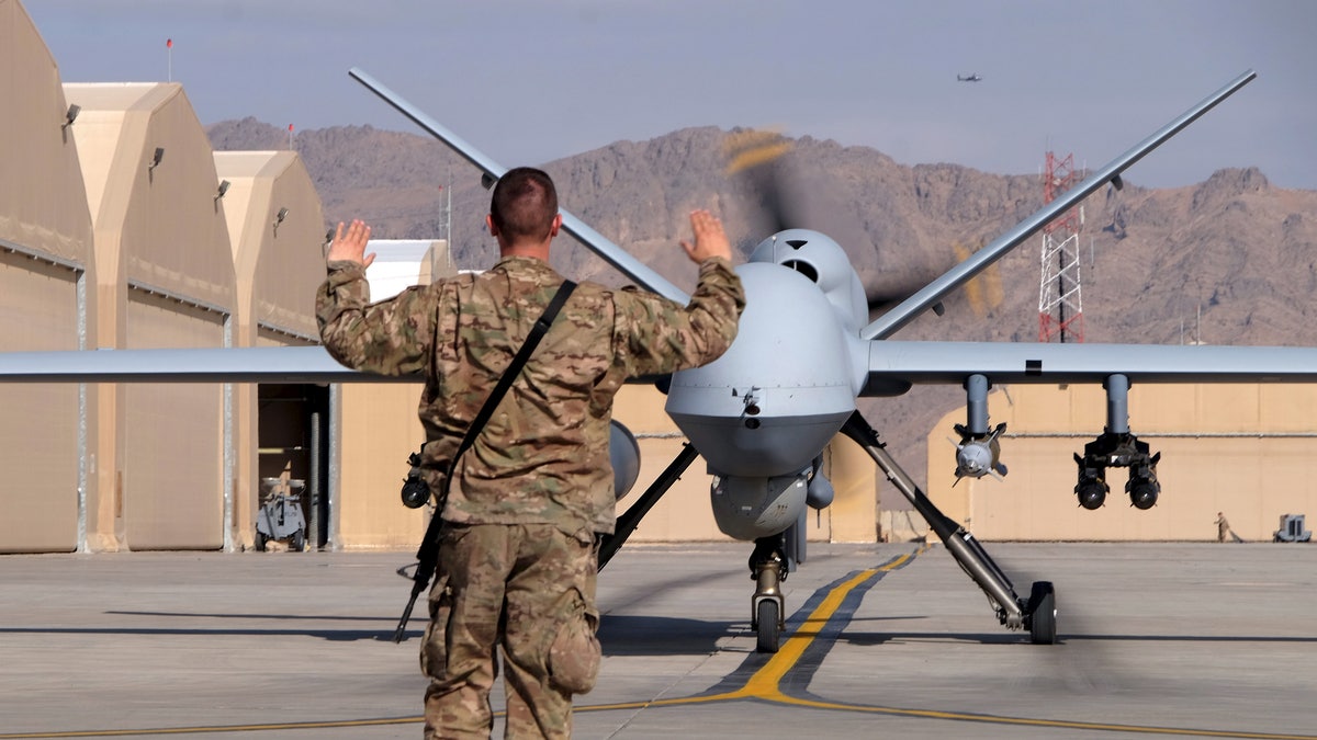 A U.S. airman guides a U.S. Air Force MQ-9 Reaper drone as it taxis to the runway at Kandahar Airfield, Afghanistan March 9, 2016. To match Exclusive AFGHANISTAN-DRONES/ REUTERS/Josh Smith/File photo - RTX2AKO8