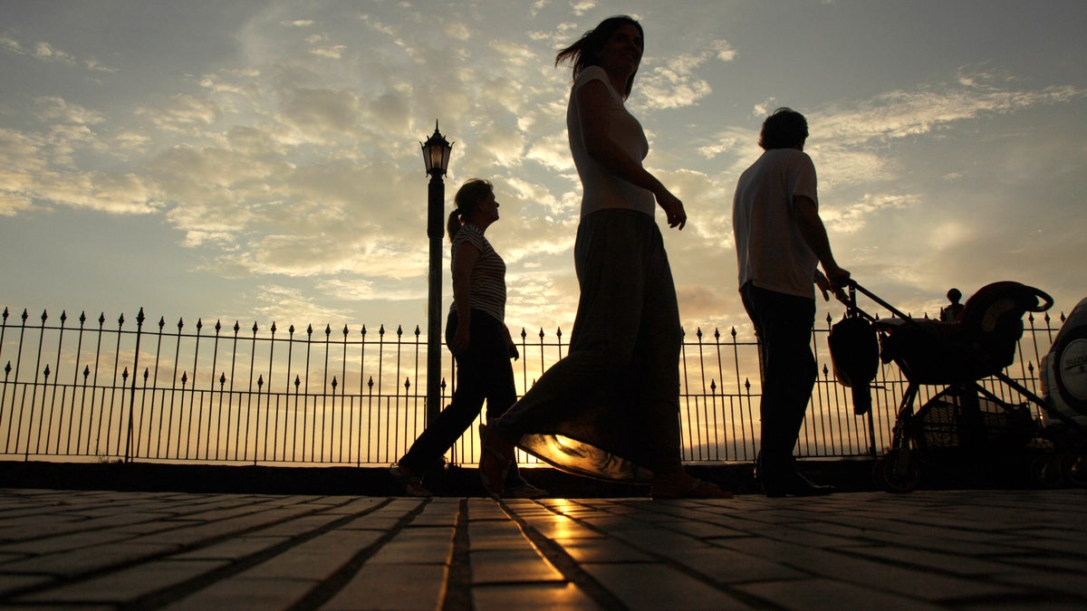 People walk during the sunset in Panama City, Wednesday, Dec. 19, 2012. A poll released Wednesday of nearly 150,000 people around the world says seven of the world's 10 countries with the most upbeat attitudes are in Latin America. In Panama and Paraguay, 85 percent of those polled said yes to all five, putting those countries at the top of the list. They were followed closely by El Salvador, Venezuela, Trinidad and Tobago, Thailand, Guatemala, the Philippines, Ecuador and Costa Rica. (AP Photo/Arnulfo Franco)