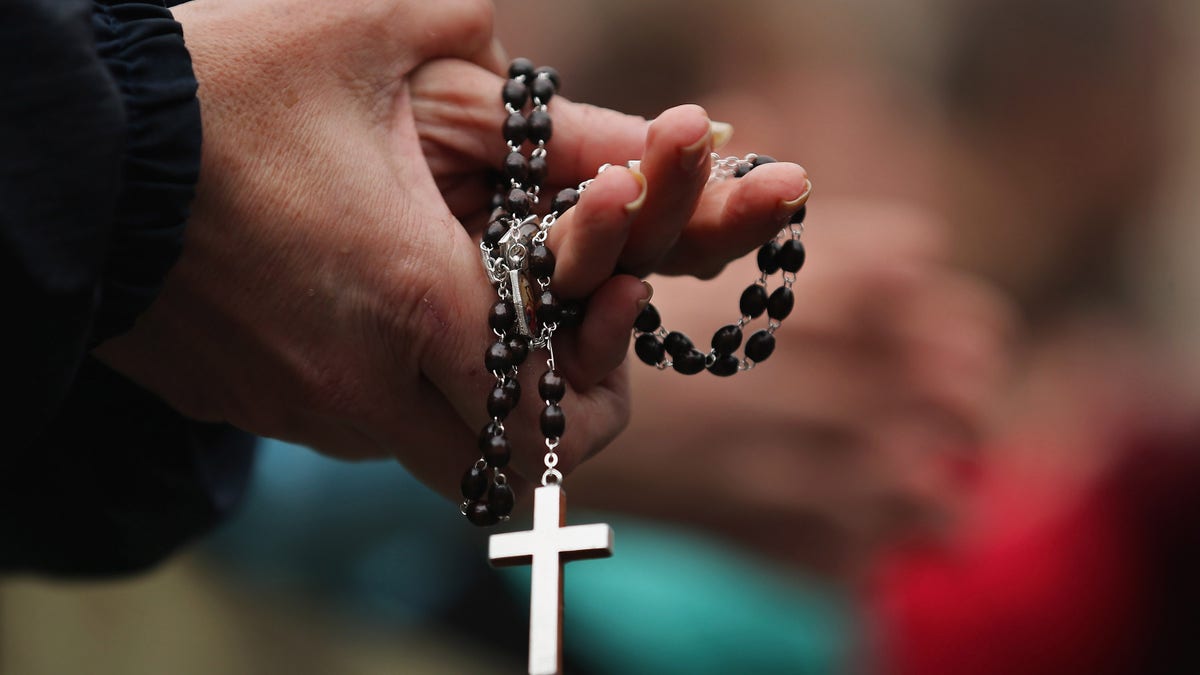 VATICAN CITY, VATICAN - MARCH 13: A woman holds rosary beads while she prays and waits for smoke to emanate from the chimney on the roof of the Sistine Chapel which will indicate whether or not the College of Cardinals have elected a new Pope on March 13, 2013 in Vatican City, Vatican. Pope Benedict XVI's successor is being chosen by the College of Cardinals in Conclave in the Sistine Chapel. The 115 cardinal-electors, meeting in strict secrecy, will need to reach a two-thirds-plus-one vote majority to elect the 266th Pontiff. (Photo by Dan Kitwood/Getty Images)