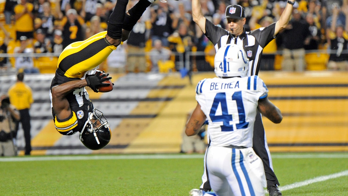 Pittsburgh Steelers wide receiver Antonio Brown (84), left, flips into the end zone over Indianapolis Colts defensive back Antoine Bethea (41) for a touchdown in the first quarter of an NFL football preseason game on Sunday, Aug. 19, 2012 in Pittsburgh. (AP Photo/Don Wright)