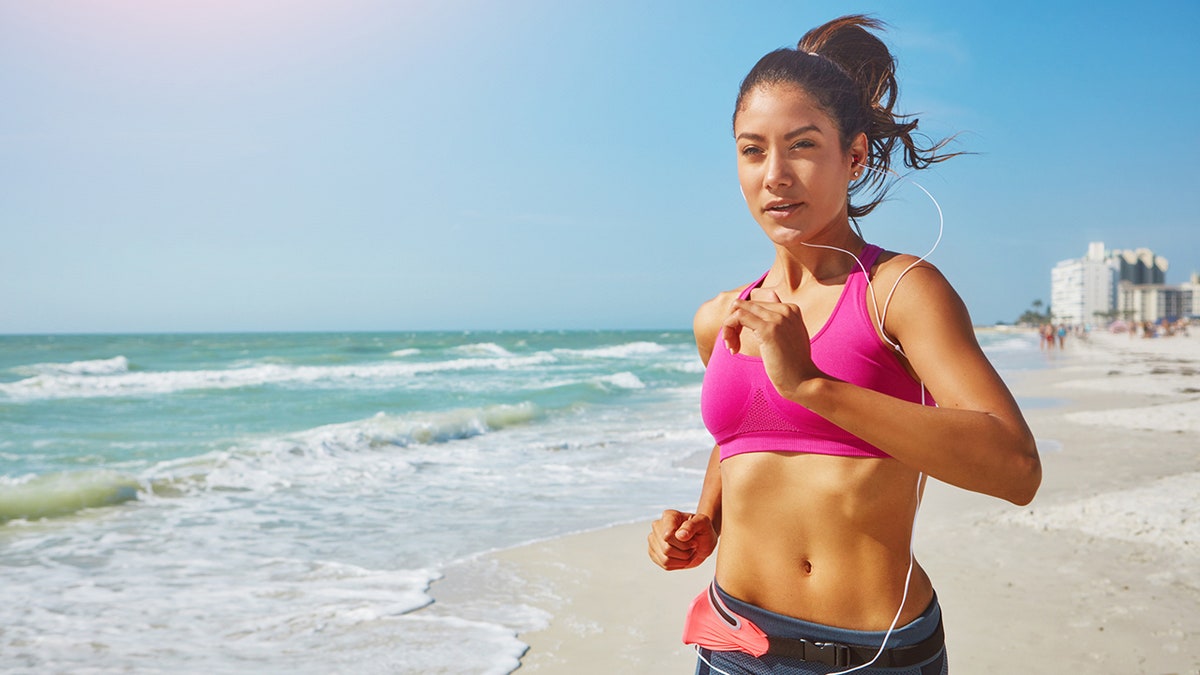 woman running beach istock