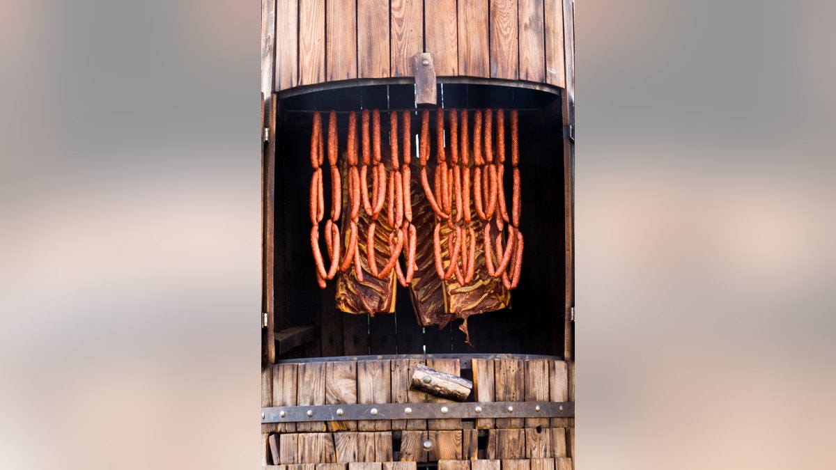 sausages and bacon in traditional smoker