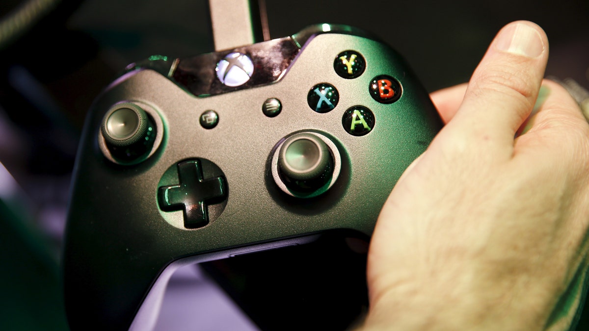 An attendee holds a Microsoft Xbox controller while playing a video game at the Electronic Entertainment Expo, or E3, in Los Angeles, California, United States, June 17, 2015. Virtual reality gaming, once a distant concept, became the new battleground at this year's E3 industry convention, with developers seeking to win over fans with their immersive headsets and accessories. REUTERS/Lucy Nicholson  - GF10000131303