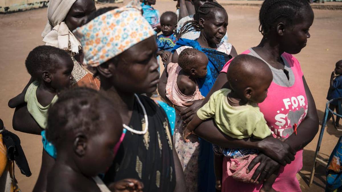 In this photo taken Monday, March 13, 2017, mothers hold their children as they wait to have them screened for malnutrition at a UNICEF-supported Outpatient Therapeutic Program in Aweil, South Sudan. The United Nations said Saturday, April 8, 2017 that civilians and aid workers in South Sudan have seen an alarming rise in attacks and harassment in the past week as the country faces both civil war and famine, accusing both government and opposition forces. (Mackenzie Knowles-Coursin/UNICEF via AP)