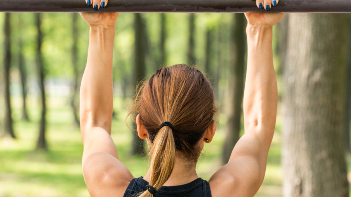 e83f4c02-Back view of female doing pull ups