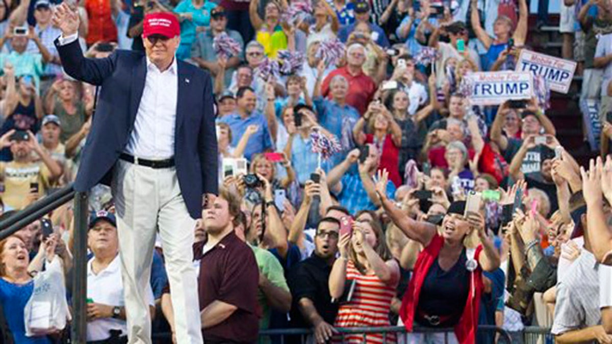 Republican presidential candidate Donald Trump waves to supporters during a campaign rally in Mobile, Ala., on Friday, Aug. 21, 2015. (AP Photo/Brynn Anderson)