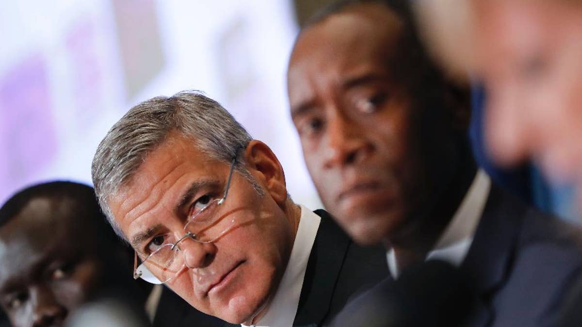 Actors George Clooney, left center, and Don Cheadle, right, during a press conference to discuss an investigation about corruption in South Sudan at the National Press Club in Washington, Monday, Sept. 12, 2016. (AP Photo/Pablo Martinez Monsivais)