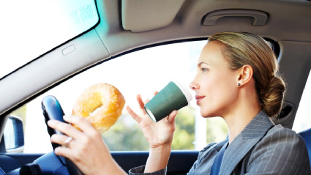Businesswoman Driving to Work and Having Breakfast