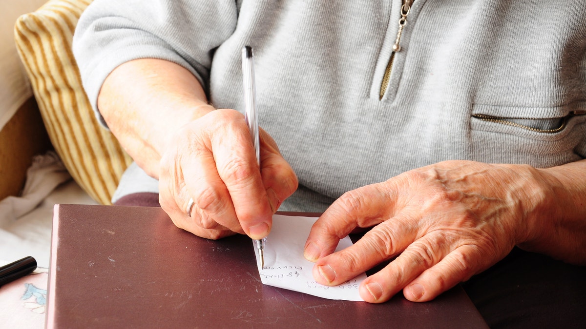elderly hands writing iStock