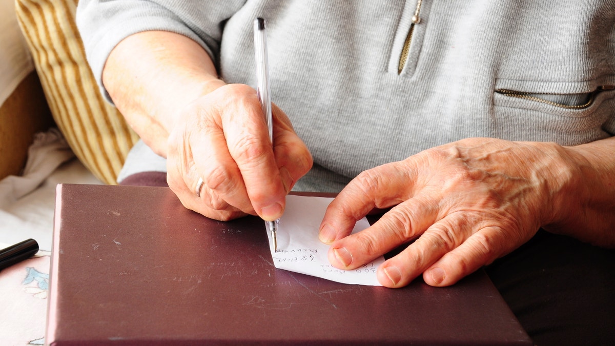 elderly hands writing iStock