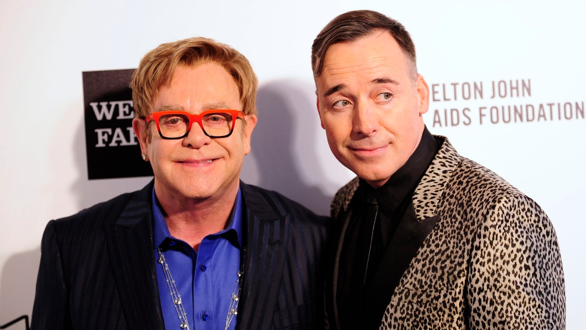 Musician Elton John (L) and his husband David Furnish arrive at the 2014 Elton John AIDS Foundation Oscar Party in West Hollywood, California March 2, 2014. REUTERS/Gus Ruelas (UNITED STATES TAGS: ENTERTAINMENT) (OSCARS-PARTIES) - RTR3FXFZ