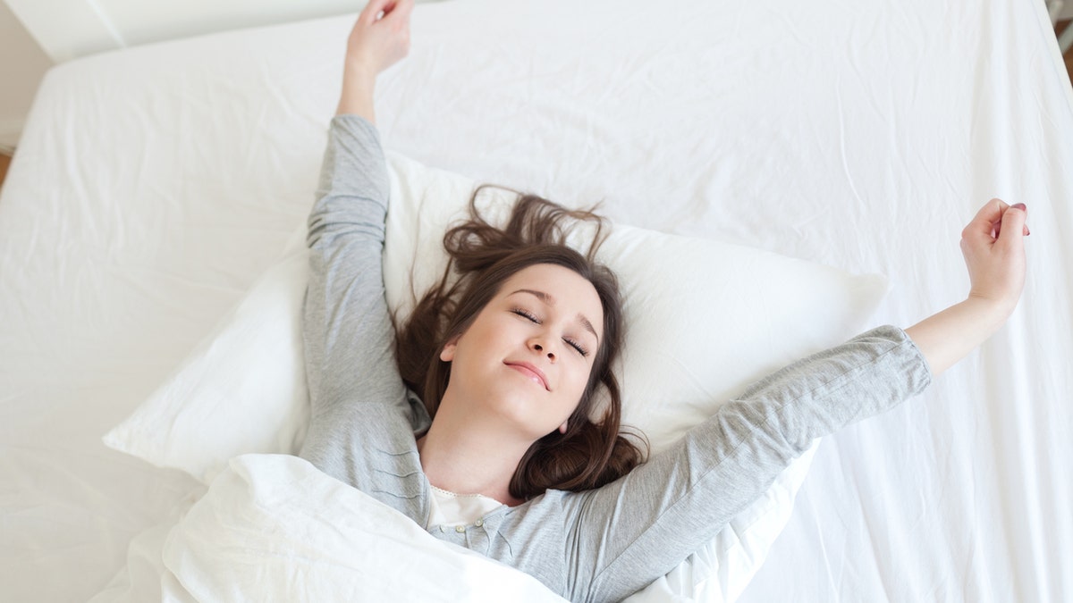 Young beautiful, woman waking up fully rested.