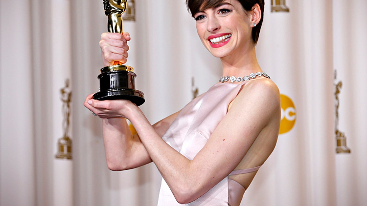 Anne Hathaway holds her Oscar for winning Best Supporting Actress for her role in "Les Miserables" at the 85th Academy Awards in Hollywood, California February 24, 2013. REUTERS/Mike Blake (UNITED STATES TAGS: - Tags: ENTERTAINMENT) (OSCARS-BACKSTAGE) - RTR3E9AJ