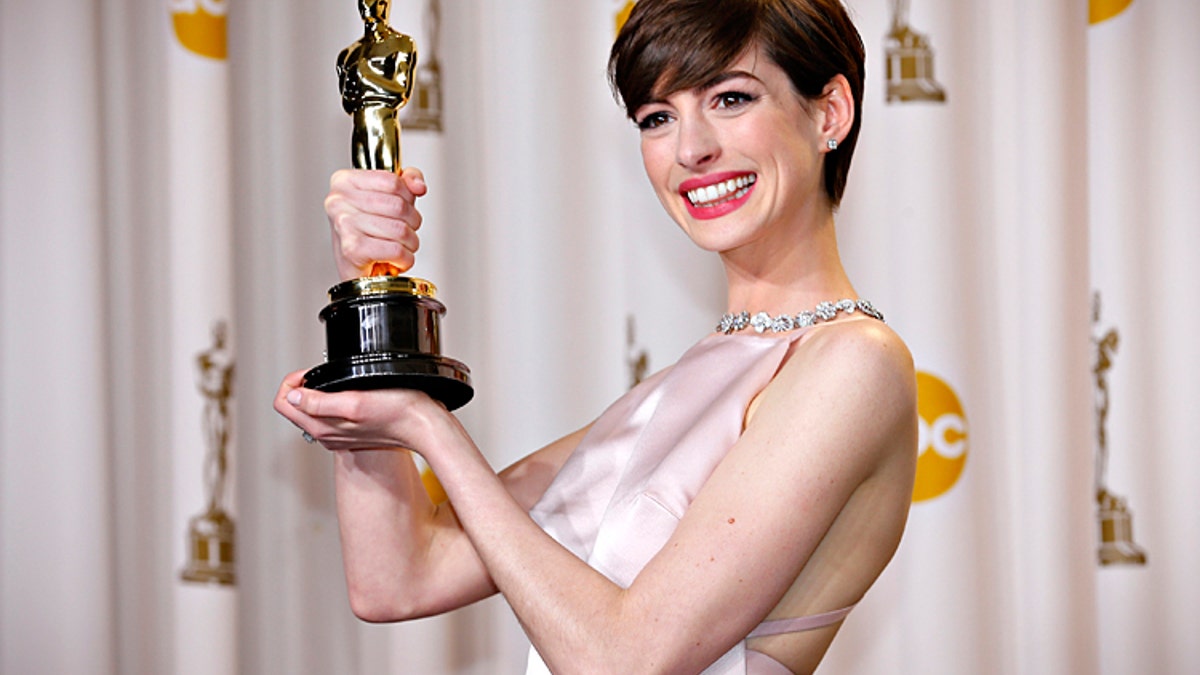 Anne Hathaway holds her Oscar for winning Best Supporting Actress for her role in "Les Miserables" at the 85th Academy Awards in Hollywood, California February 24, 2013. REUTERS/Mike Blake (UNITED STATES TAGS: - Tags: ENTERTAINMENT) (OSCARS-BACKSTAGE) - RTR3E9AJ