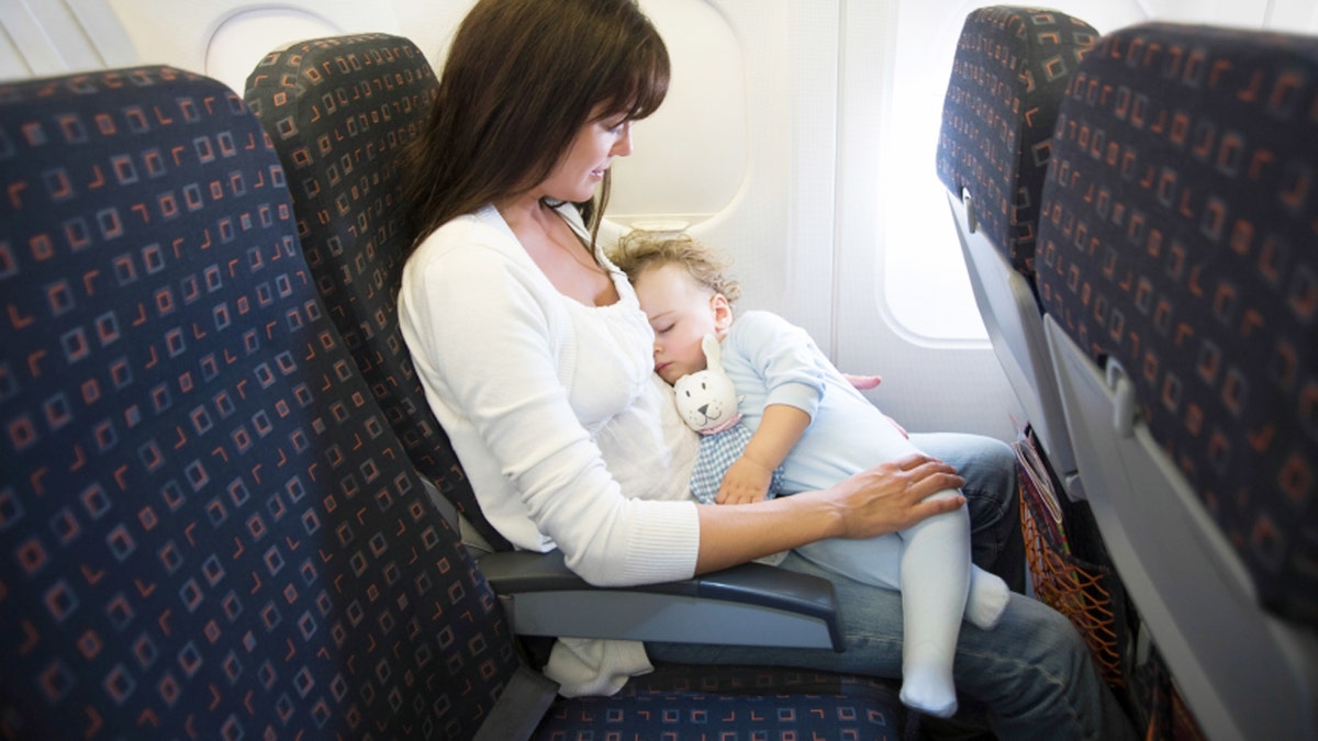 Baby Sleeping On Mother's Laps In Airplane