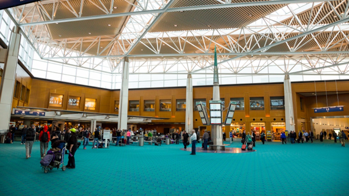 Travelers walk over the iconic green carpet of Portland International Airport in 2014. 