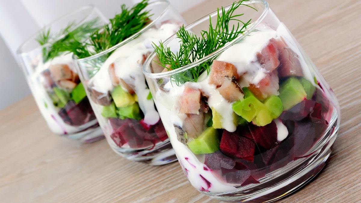 Appetizer in a glass of beet and herring with avocado