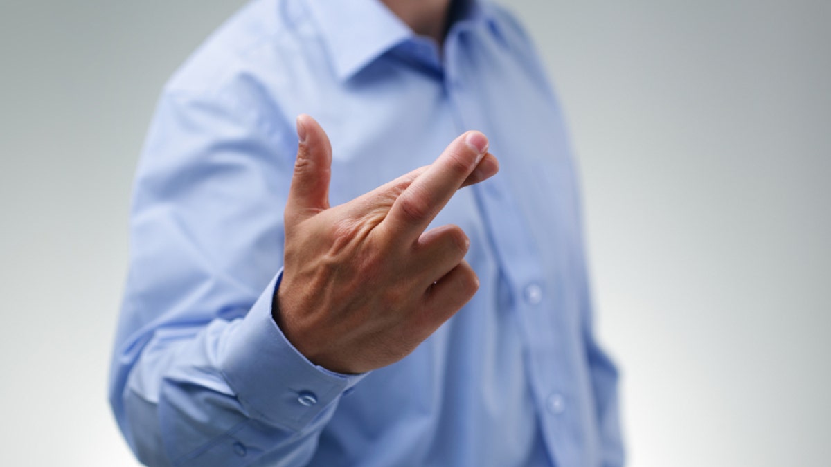 Businessman with fingers crossed