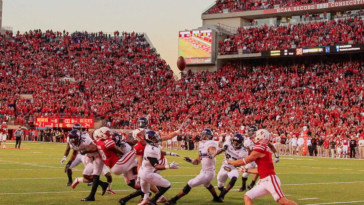 In this image from Nov. 2, 2013, a scrum of Nebraska and Northwestern players follow a tipped ball after Nebraska wide receiver Quincy Enunwa (18), Northwestern center back Dwight White (2), safety Traveon Henry (10), and safety Ibraheim Campbell (24), vied for a ball thrown by Nebraska quarterback Ron Kellogg III (12) with no time on the clock, in an NCAA college football game in Lincoln, Neb.The ball was subsequently caught by Nebraska wide receiver Jordan Westerkamp, right, for a touchdown, giving Nebraska a 27-24 win. If Nebraska makes it back to the Big Ten championship game, the Cornhuskers might look at Westerkamp's tipped-ball touchdown on the last play against Northwestern as the one that saved their season and maybe even Bo Pelini's job. (AP Photo/Nati Harnik)