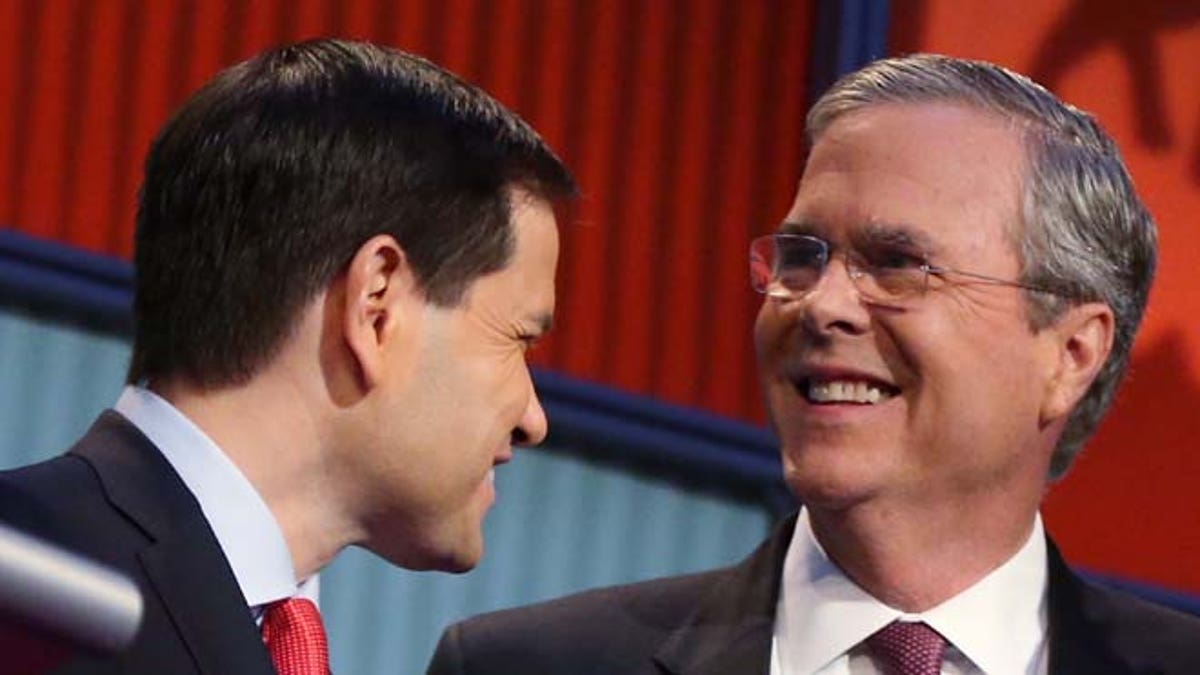 FILE - In this Aug. 6, 2015, file photo, Republican presidential candidates Marco Rubio, left, and Jeb Bush talk during a break during the first Republican presidential debate at the Quicken Loans Arena in Cleveland. Bush collected $13.4 million in recent months for his White House campaign, while competitor Rubio ended September with more available cash in the bank despite having raised less than half as much. (AP Photo/Andrew Harnik)