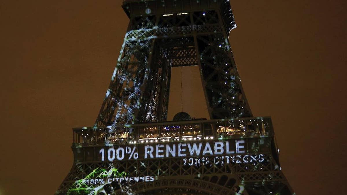 FILE- In this Sunday, Nov. 29, 2015 file photo, an artwork entitled 'One Heart One Tree' by artist Naziha Mestaoui is displayed on the Eiffel tower ahead of the 2015 Paris Climate Conference, in Paris.  The Paris Agreement on climate change comes into force Friday Nov. 4, 2016, after a year with remarkable success in international efforts to slash man-made emissions of carbon dioxide and other global warming gases. (AP Photo/Thibault Camus, FILE)