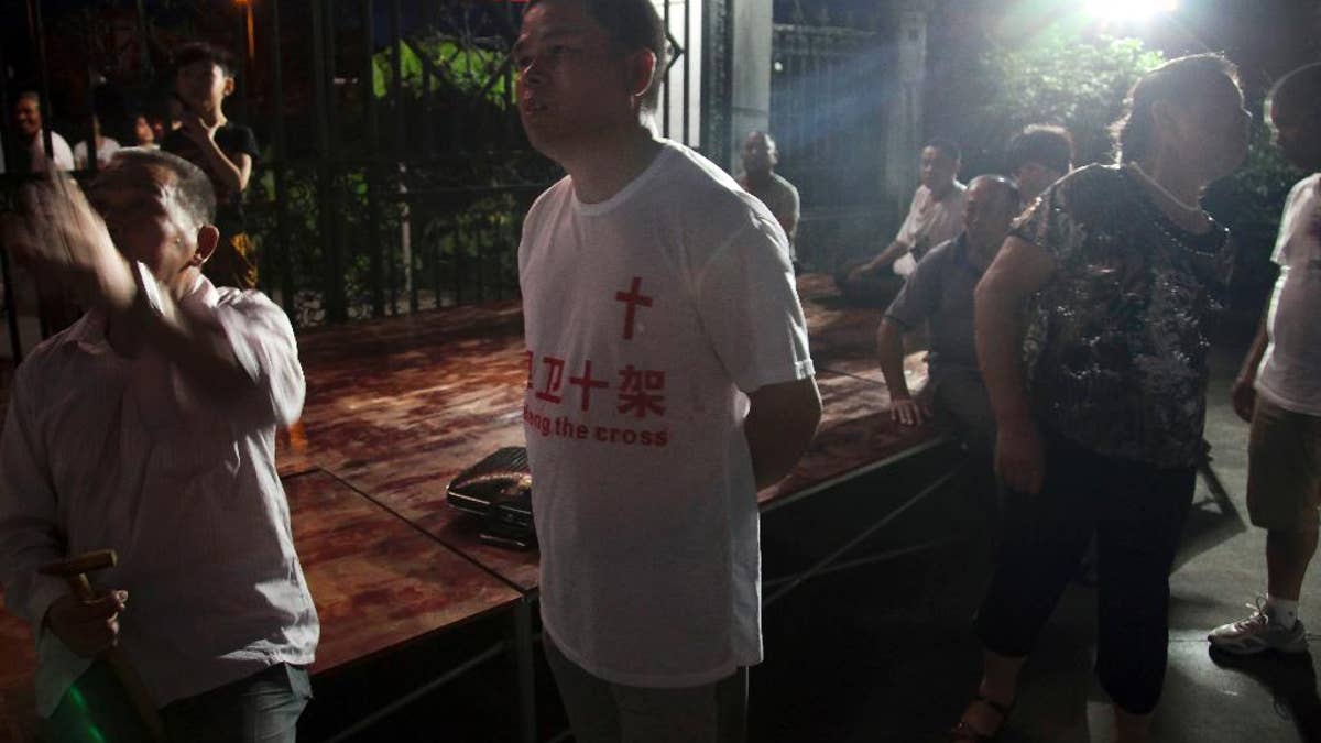 In this photo taken July 16, 2014, a church member wears a T-shirt with the Chinese words 