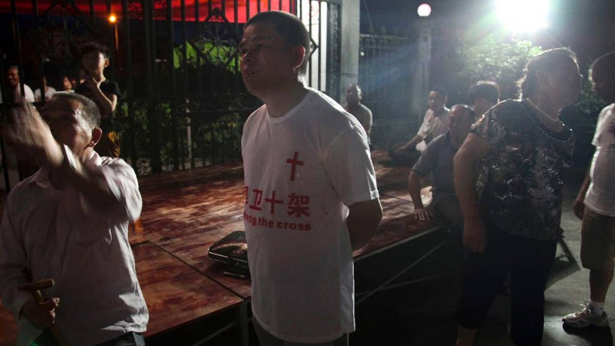 In this photo taken July 16, 2014, a church member wears a T-shirt with the Chinese words 