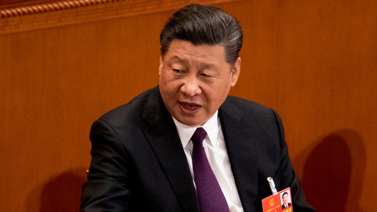 Chinese President Xi Jinping talks to leaders after being formally re-elected to a second term as China's President during a plenary session of China's National People's Congress at the Great Hall of the People in Beijing, Saturday, March 17, 2018. Xi was reappointed Saturday as China's president with no limit on the number of terms he can serve. The ceremonial National People's Congress voted unanimously for Xi's second five-year term as president. (AP Photo/Andy Wong)