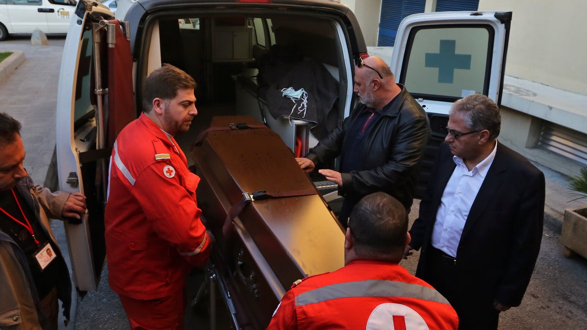 Lebanese Red Cross workers carry the coffin of British doctor Abbas Khan, 32, who was seized by Syrian government troops in November 2012, into the Hotel-Dieu de France hospital in Beirut, Lebanon, Saturday, Dec. 21, 2013. The circumstances in which Khan, died while in detention in Syria remain in dispute. A senior British official has accused Syrian President Bashar Assad's government of effectively murdering Khan, while the Syrian authorities say the doctor committed suicide and there was no sign of violence or abuse. (AP Photo/Bilal Hussein)