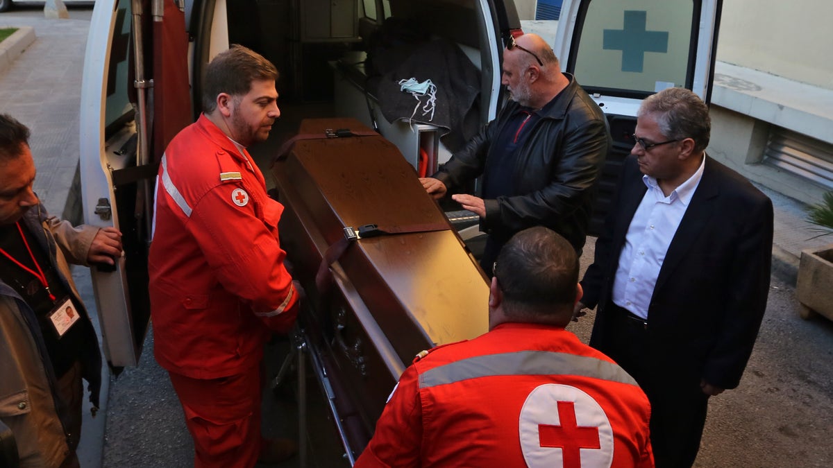 Lebanese Red Cross workers carry the coffin of British doctor Abbas Khan, 32, who was seized by Syrian government troops in November 2012, into the Hotel-Dieu de France hospital in Beirut, Lebanon, Saturday, Dec. 21, 2013. The circumstances in which Khan, died while in detention in Syria remain in dispute. A senior British official has accused Syrian President Bashar Assad's government of effectively murdering Khan, while the Syrian authorities say the doctor committed suicide and there was no sign of violence or abuse. (AP Photo/Bilal Hussein)