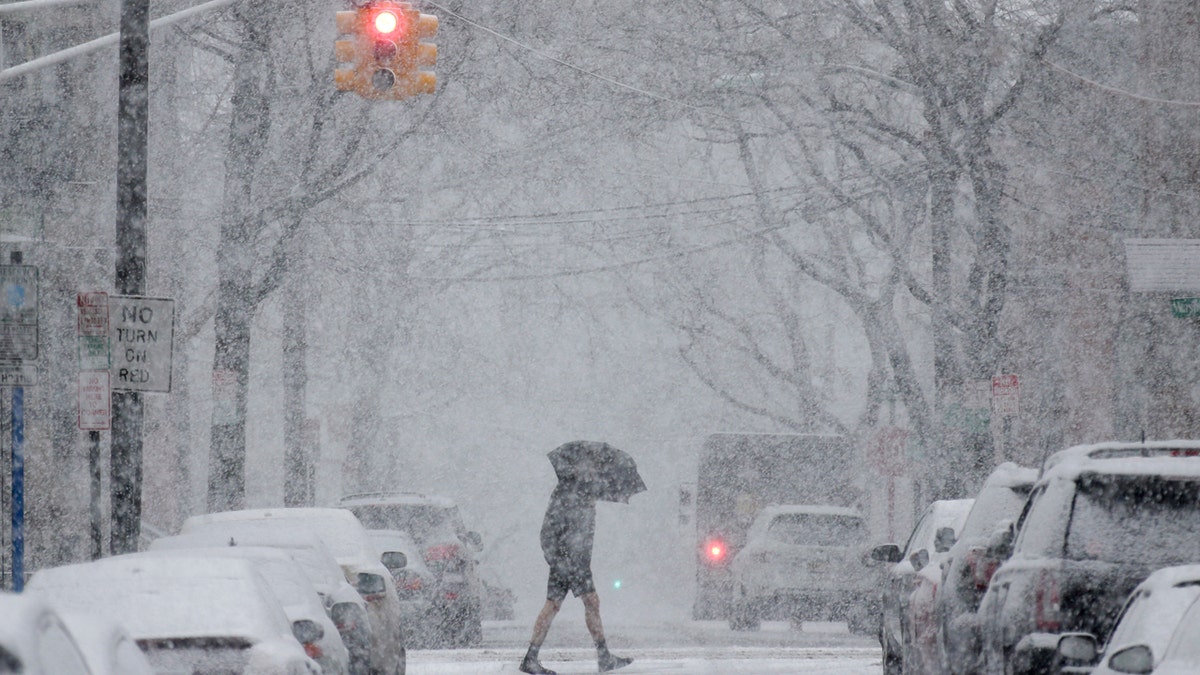 A man crosses the street through heavy snow in Hoboken, N.J., Wednesday, March 7, 2018. (AP Photo/Seth Wenig)