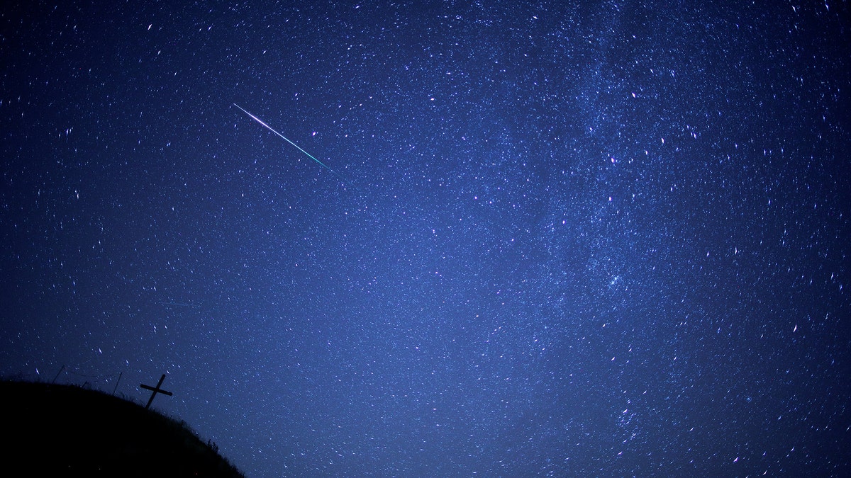 A meteor streaks past the Milky Way in the night sky above Leeberg hill during the Perseid meteor shower in Grossmugl, Austria, August 12, 2018. Picture taken August 12, 2018. REUTERS/Heinz-Peter Bader - RC1523F89E50